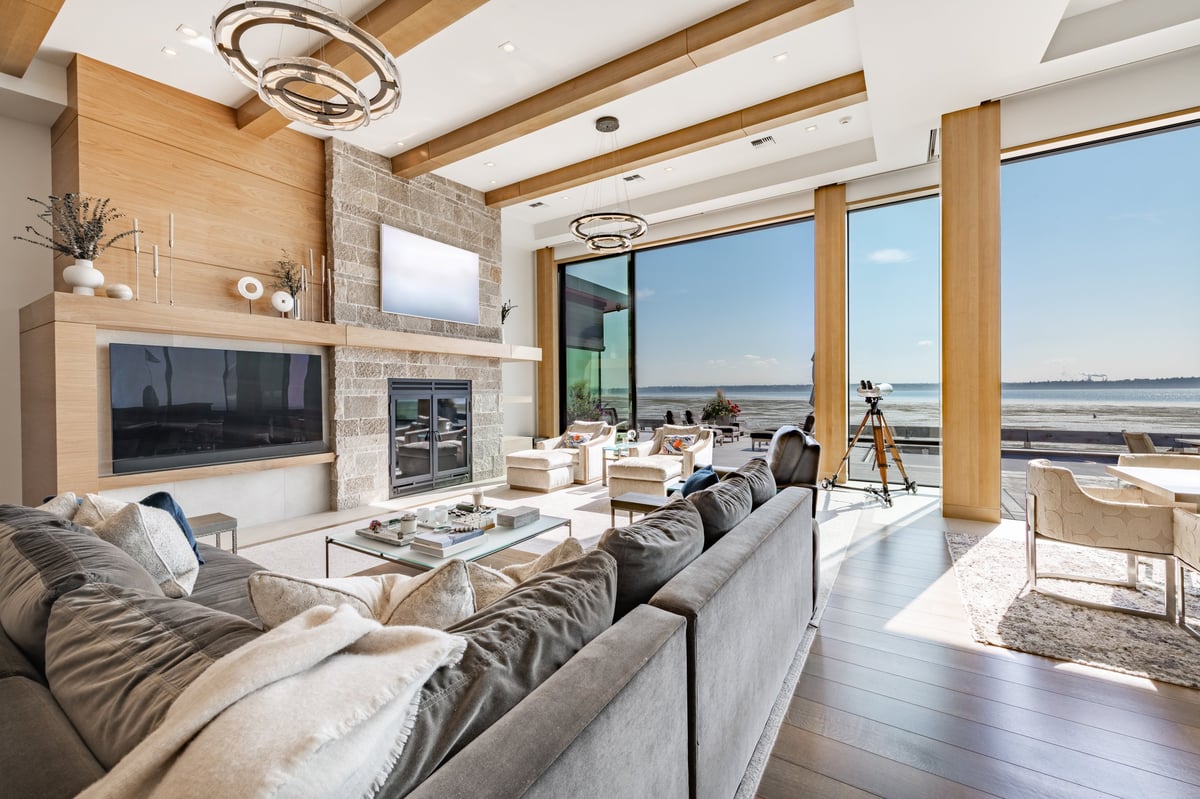 Luxurious mountain modern living room with ocean view, designer furniture and panoramic windows